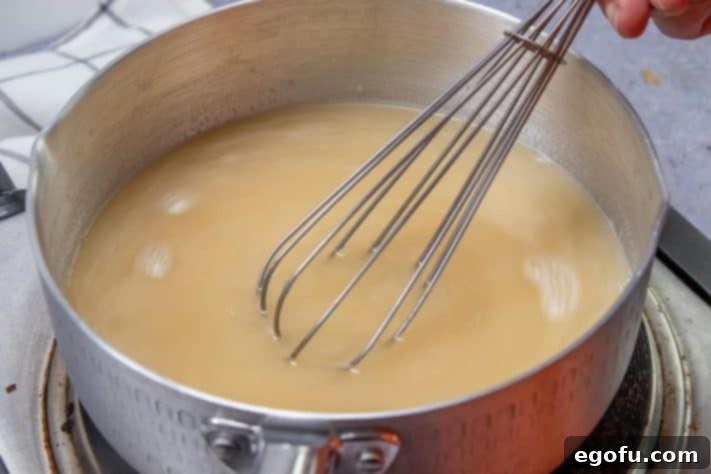 Decadent White Chicken Enchiladas 18 Chicken broth added to saucepan.
