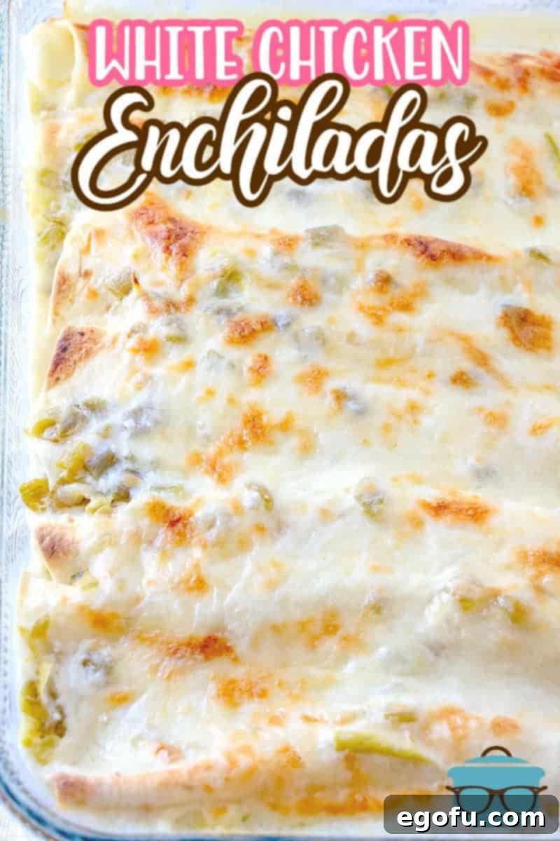 Decadent White Chicken Enchiladas 13 Fulled cooked white chicken enchiladas shown in a clear Pyrex baking dish.