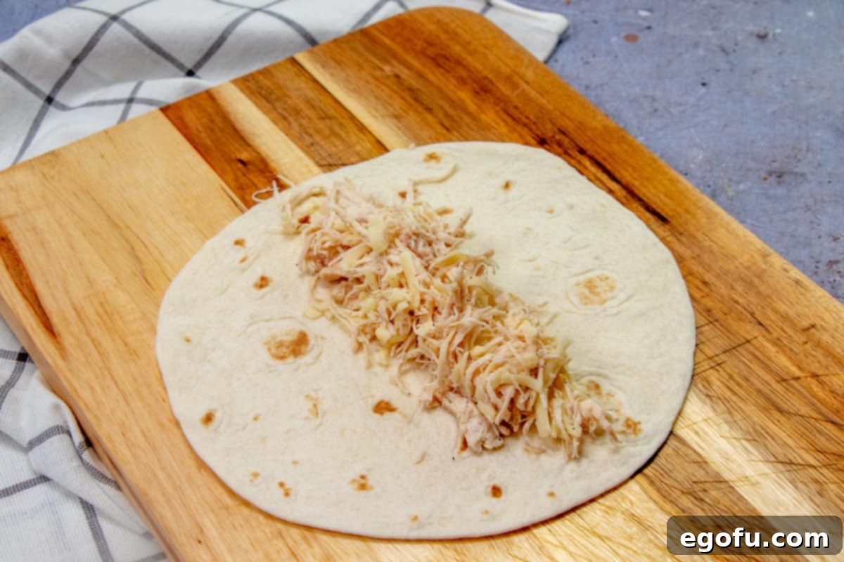 Decadent White Chicken Enchiladas 6 Chicken and cheese filling placed into the center of a flour tortilla