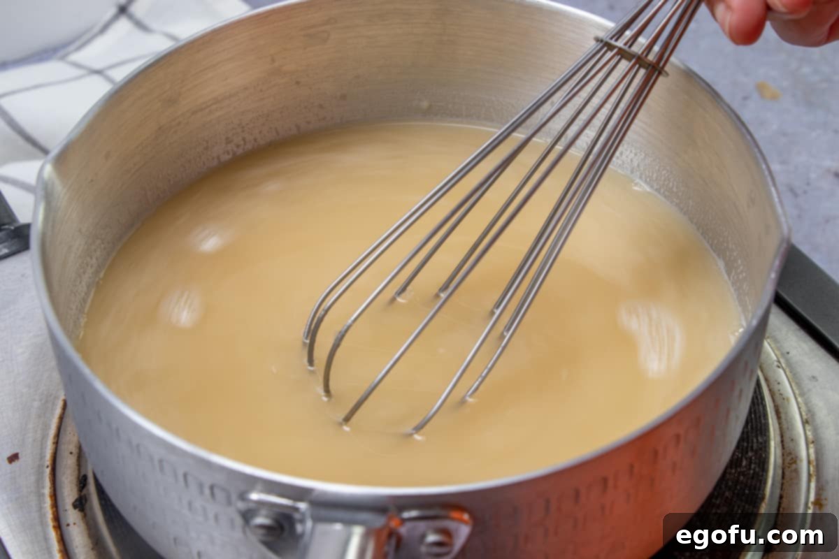 Decadent White Chicken Enchiladas 9 Whisking in chicken broth to butter, flour mixture