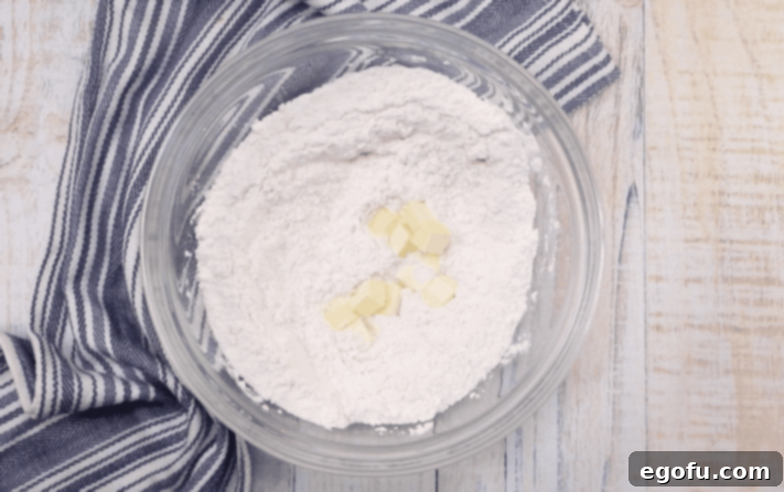 flour, baking soda and cubed butter in a clear bowl