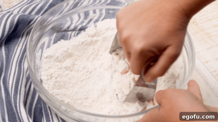 pastry cutter being used in a bowl of flour.
