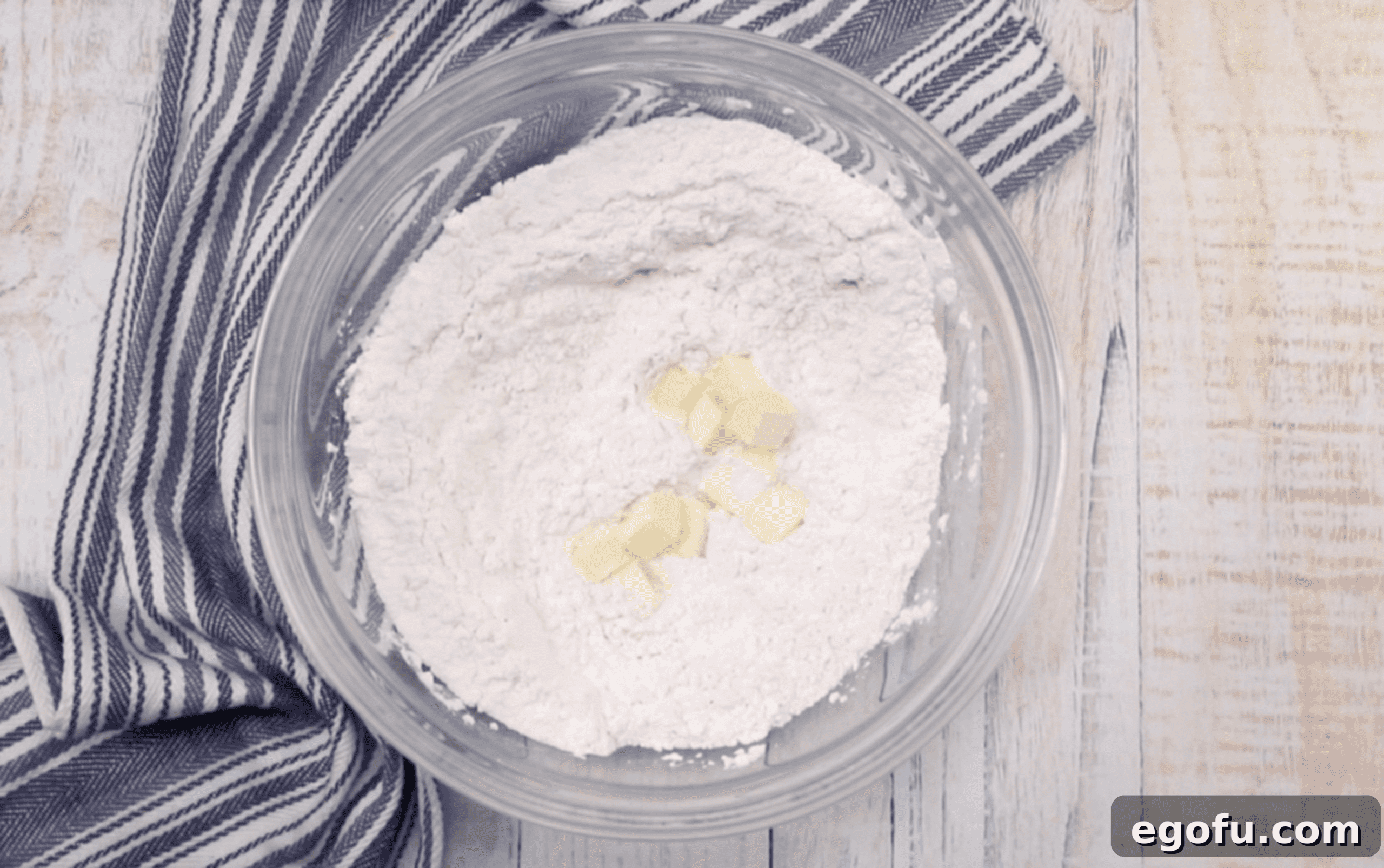 flour, baking soda and cubed butter in a clear bowl