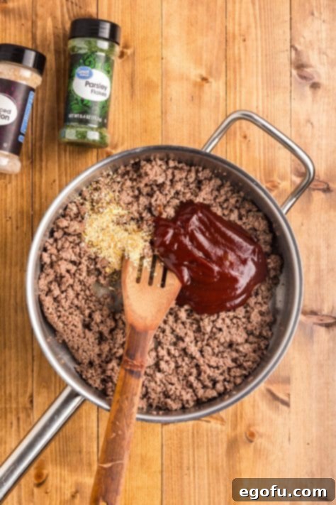 Smoky Beef Biscuit Pockets 12 BBQ sauce and dried onion flakes added to cooked ground beef in a skillet.