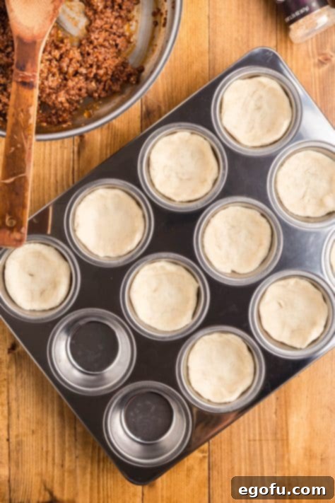 Smoky Beef Biscuit Pockets 13 Biscuits added to muffin tin, pressed into cup shapes.