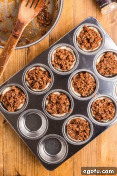 Smoky Beef Biscuit Pockets 14 BBQ beef mixture added to all the biscuits in the muffin tin.