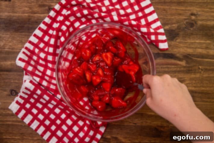 sliced strawberries and strawberry glaze mixed together in a clear bowl