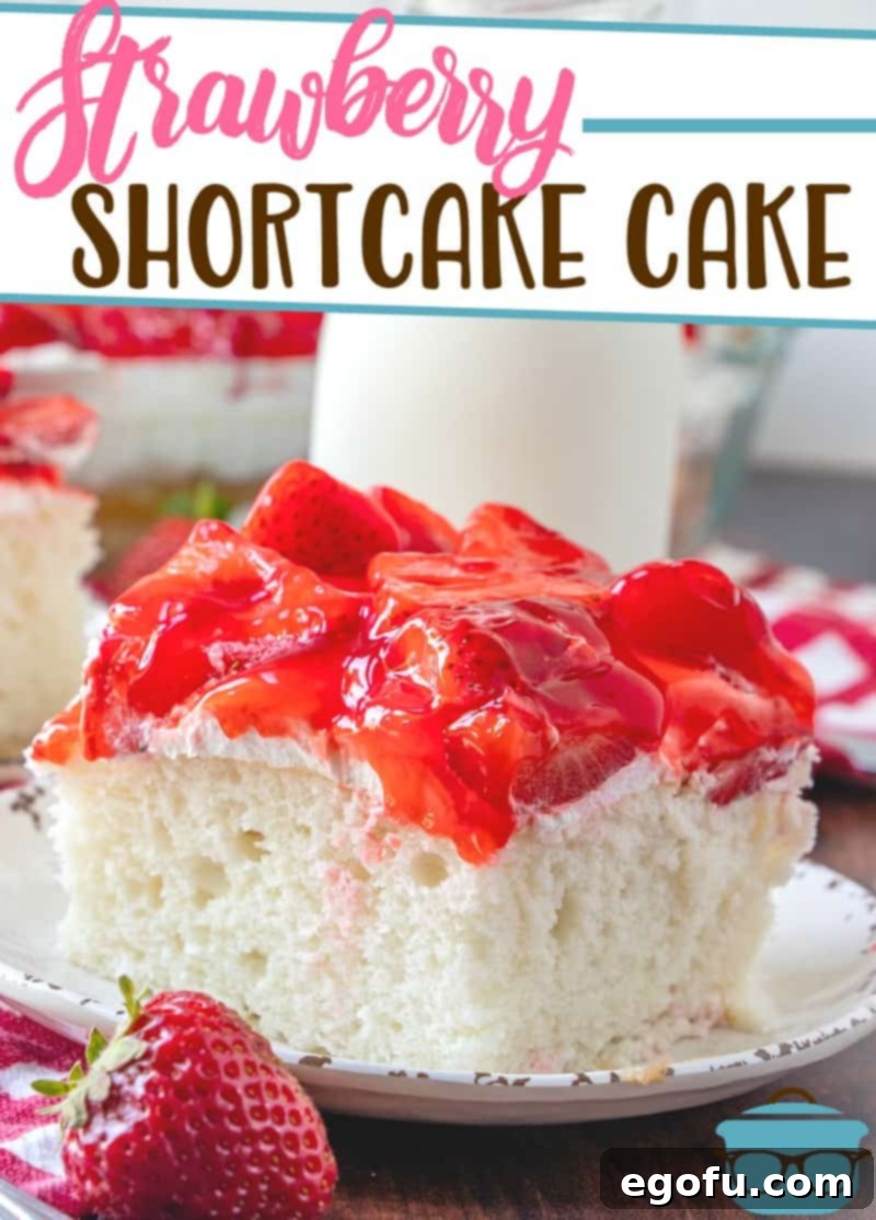 Strawberry Shortcake Cake recipe from The Country Cook, slice served on a white plate with a glass of milk pictured in the background.