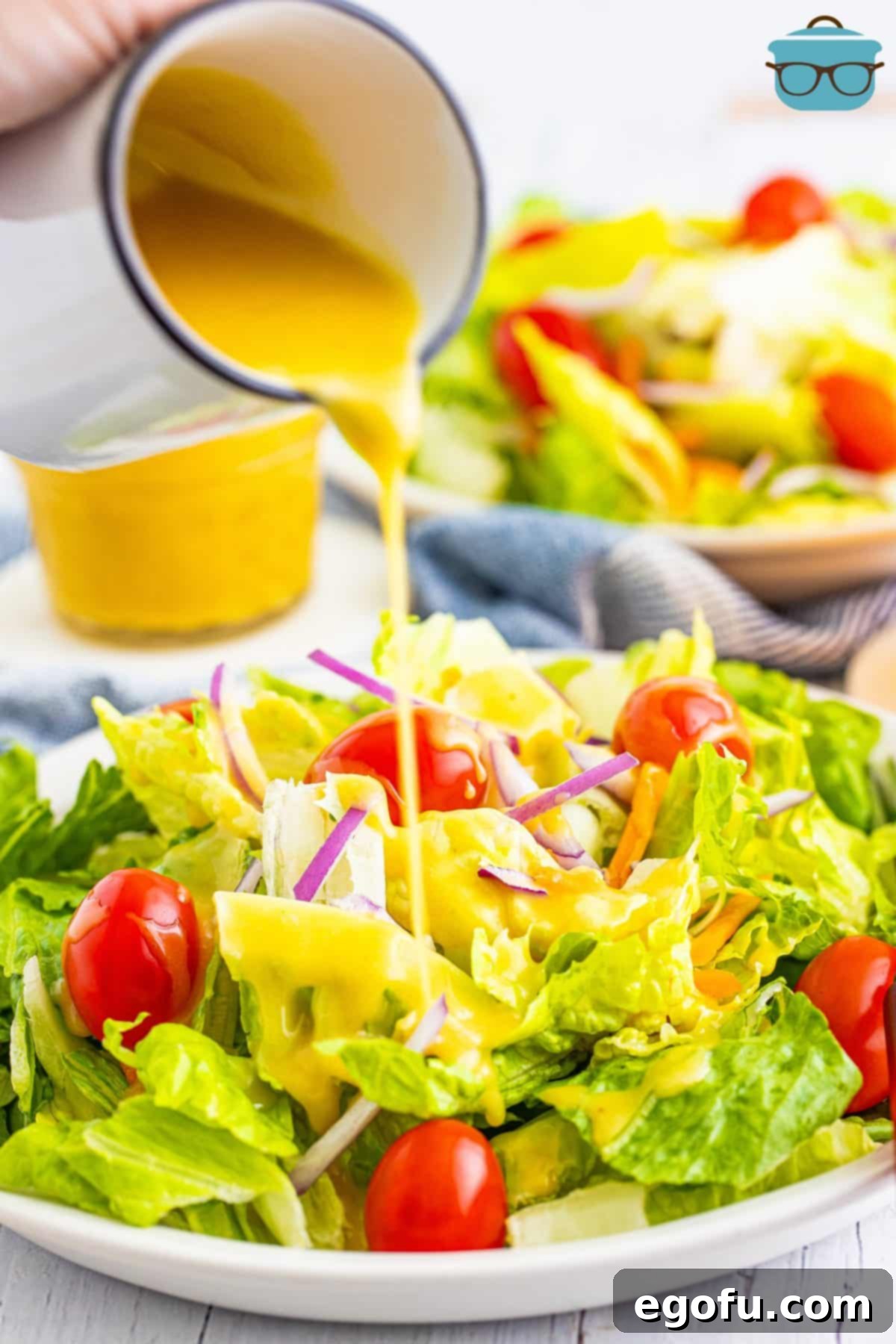 Honey Mustard in a dressing serving container being boured on a salad.