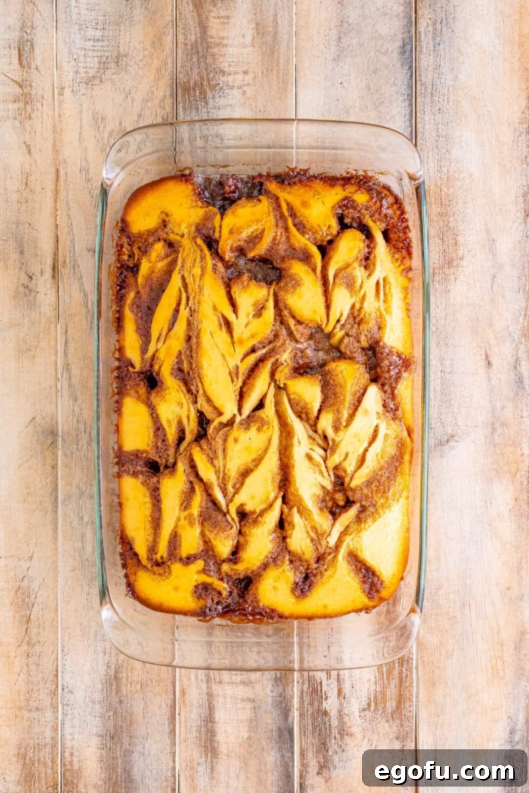 Swirl of Spice Cake 11 A fully baked Cinnamon Roll Cake, golden brown and cooling gently within its baking dish, promising deliciousness.