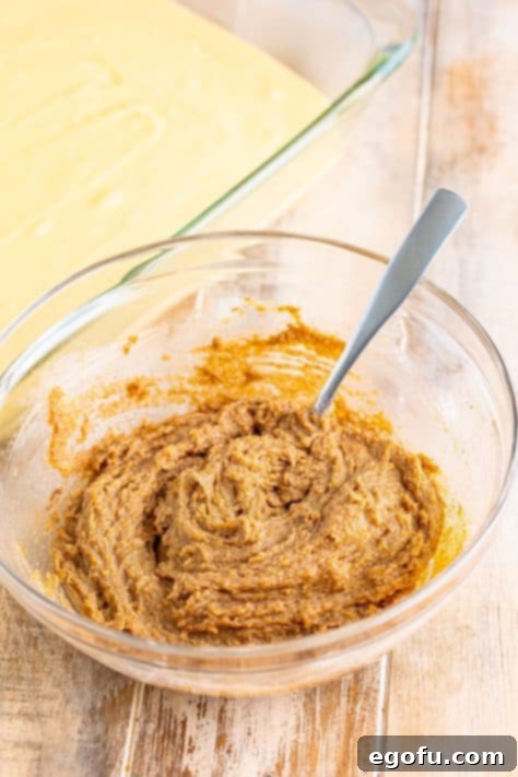 Swirl of Spice Cake 20 Rich cinnamon filling is shown in a glass bowl, being thoroughly mixed with a silver spoon until well combined.