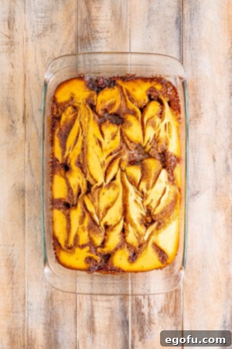 Swirl of Spice Cake 23 A fully baked Cinnamon Roll Cake, golden brown and cooling gently within its baking dish, promising deliciousness.
