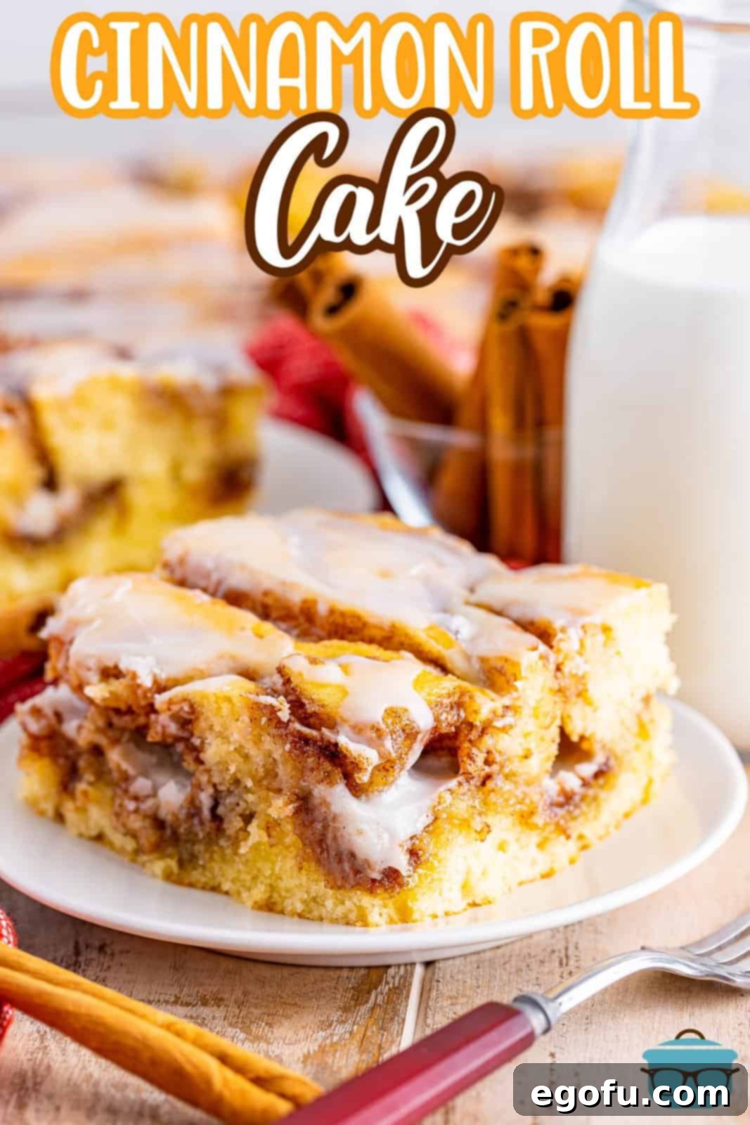 Swirl of Spice Cake 3 A glistening slice of Cinnamon Roll Cake on a white plate, with a charming small bottle of milk blurred in the background, creating a cozy and inviting scene.