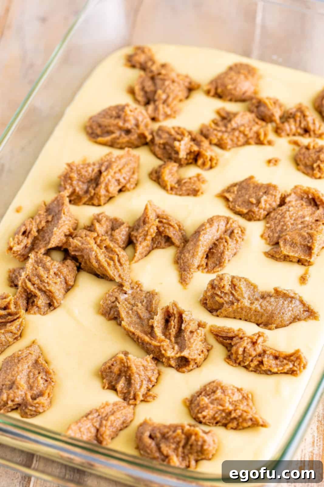 Swirl of Spice Cake 9 Small, even spoonfuls of cinnamon batter filling are dropped carefully over the raw cake batter in the baking dish, ready for swirling.