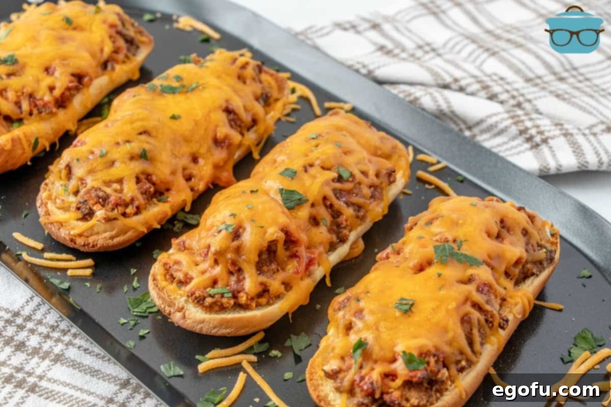 Meatloaf sandwiches, fully cooked, displayed on a silver serving tray and topped with freshly chopped parsley.