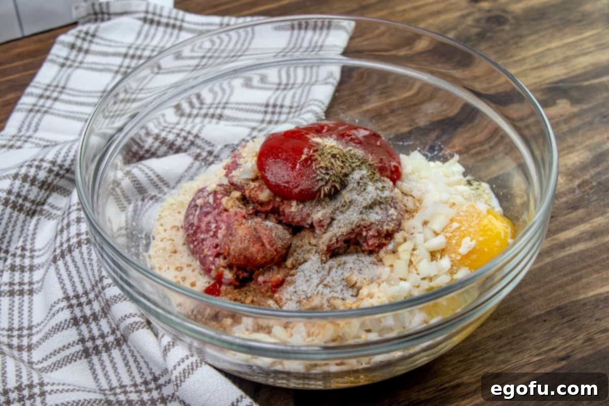 ground beef, crushed crackers, egg, onion, milk, ketchup, Worcestershire sauce, dried thyme, garlic powder in a large clear mixing bowl.