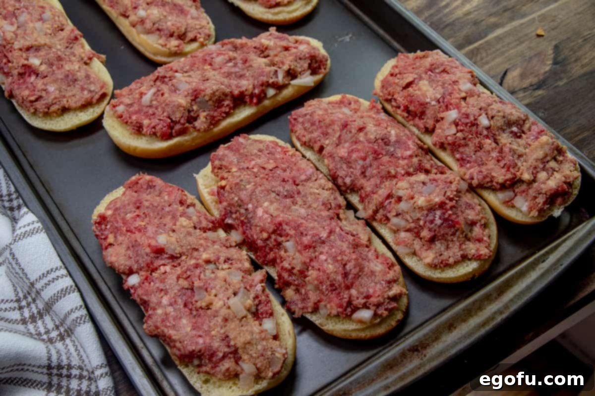 meatloaf mixture spread evenly across on top of sub roll buns.