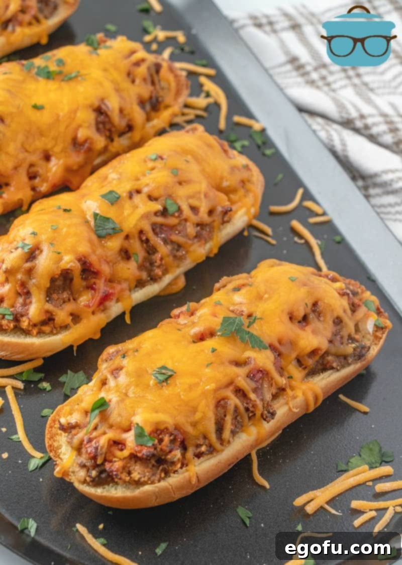 Meatloaf Patty Melts shown fully cooked on a dark silver serving tray sprinkled with shredded cheese and fresh parsley.
