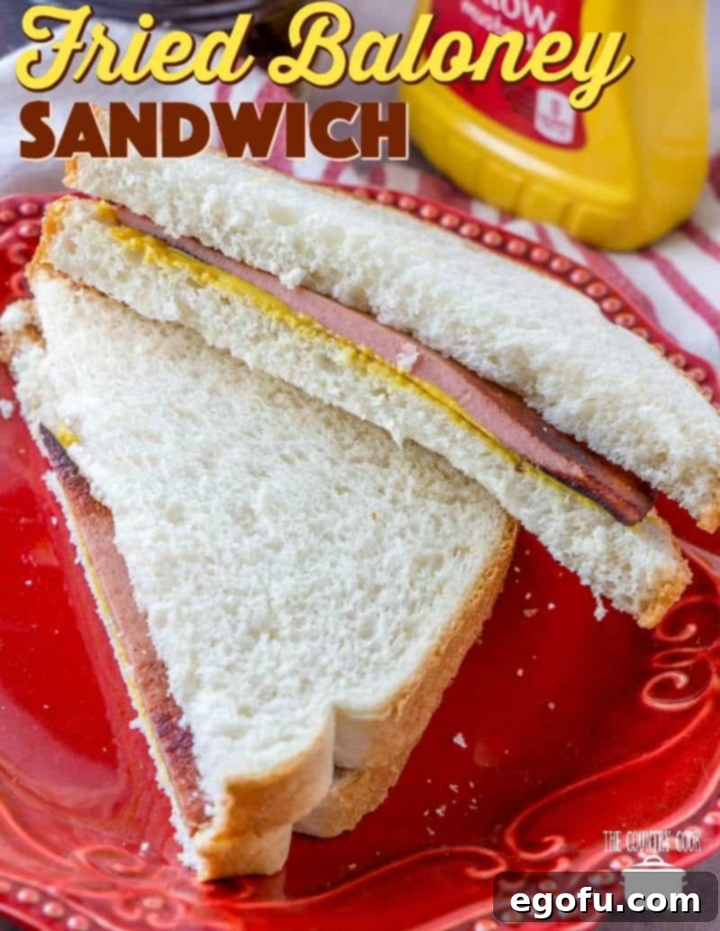 Fried Bologna (Fried Baloney) Sandwich recipe from The Country Cook. A sandwich sliced in half and stacked on top of each other on a red plate, showcasing its golden-brown crispness.