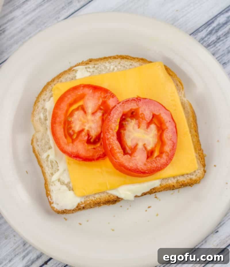 A vibrant fried bologna sandwich with soft white bread, a slice of melted cheese, and a fresh, juicy tomato slice, showcasing a delightful blend of textures and flavors.