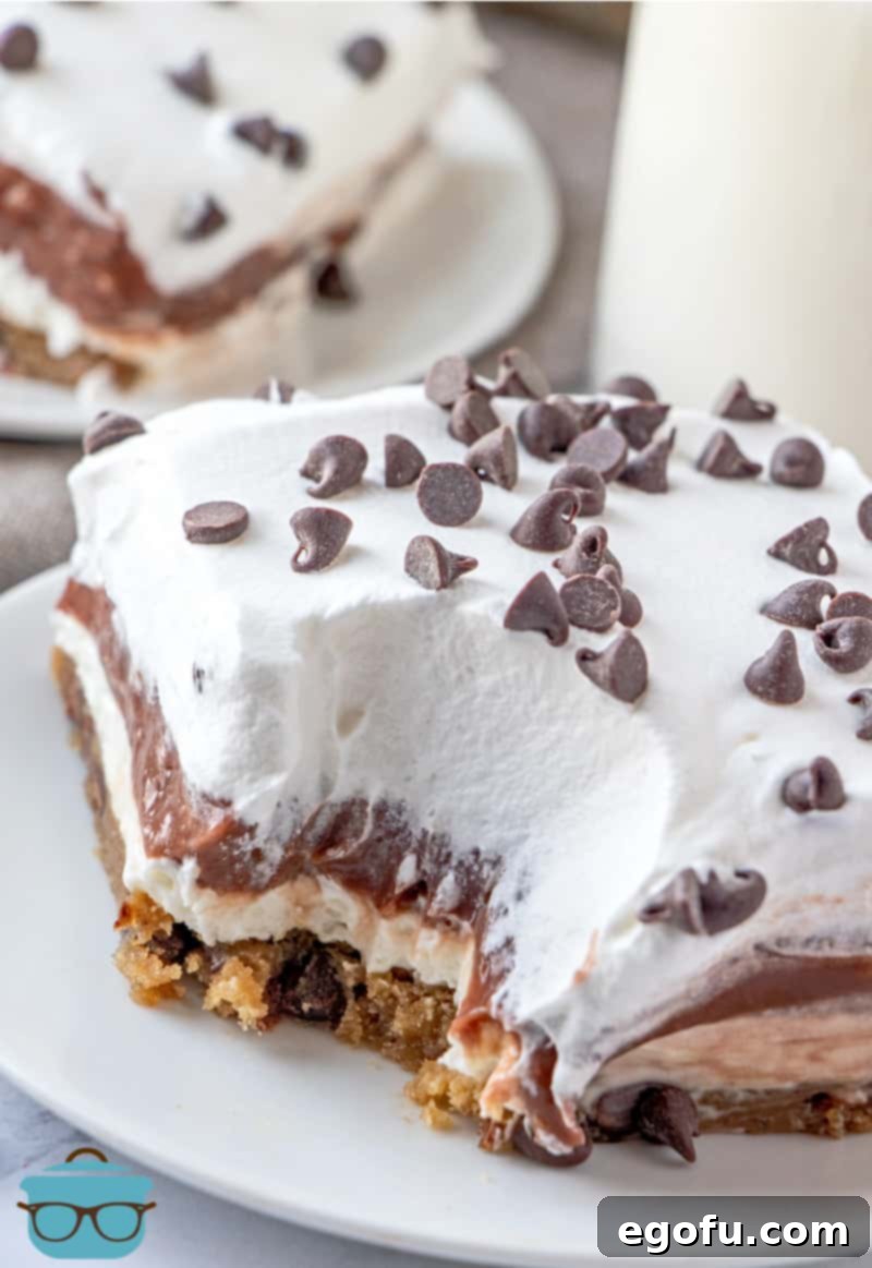 C Is For Cookie Layers 14 close up shot of Cookie Monster layered dessert that has had a small bite removed, slice shown on a round white plate.