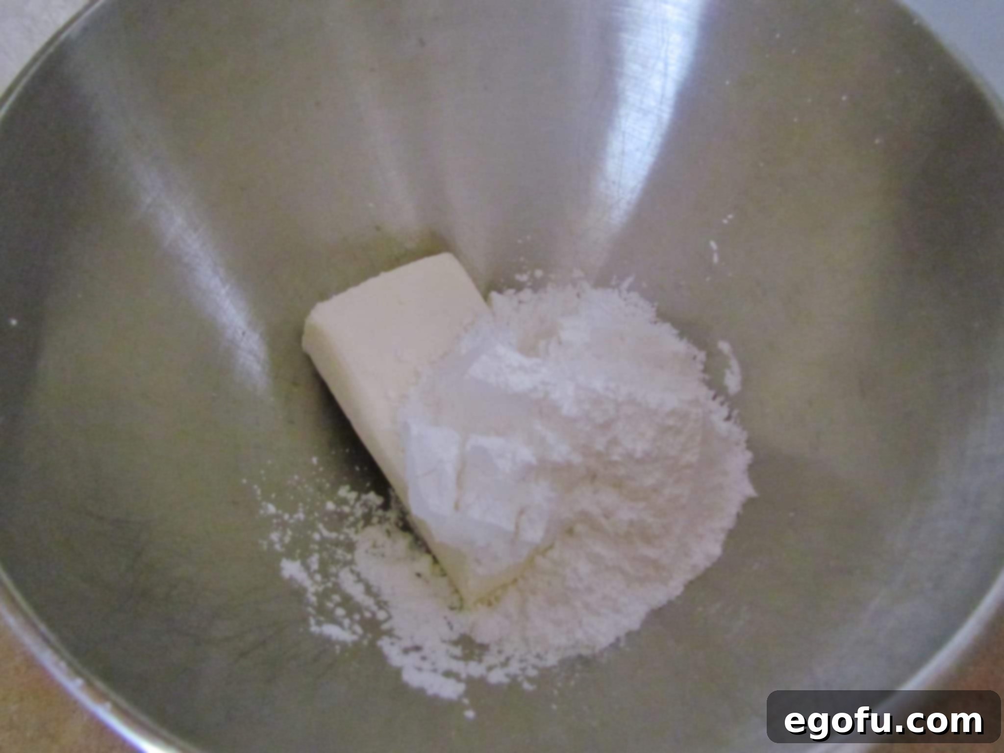 C Is For Cookie Layers 7 powdered sugar and cream cheese mixed together by an electric mixer.