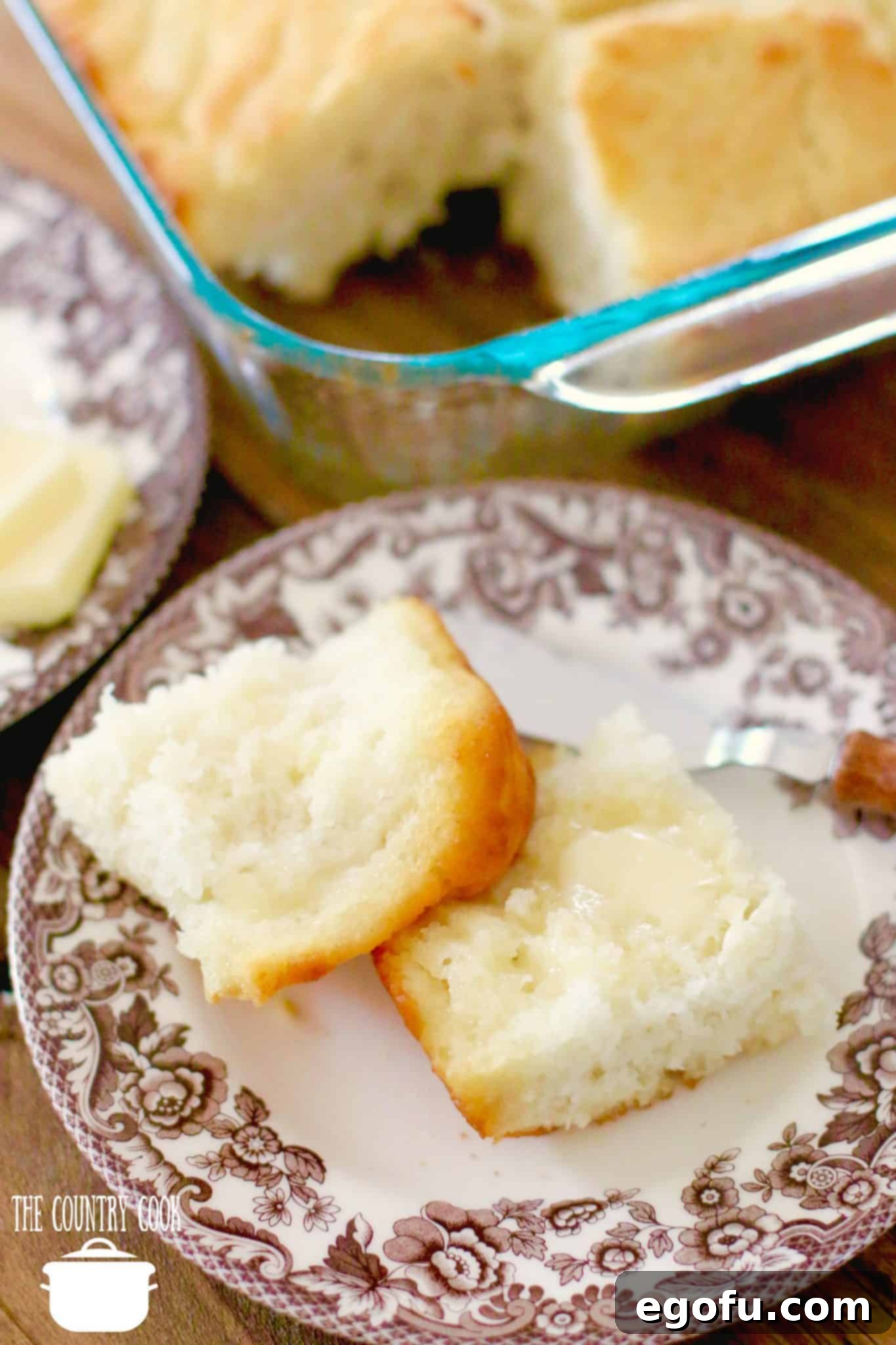Golden Butter Biscuits 14 A sliced buttermilk biscuit served with melted butter on a brown and white plate, ready to be enjoyed.