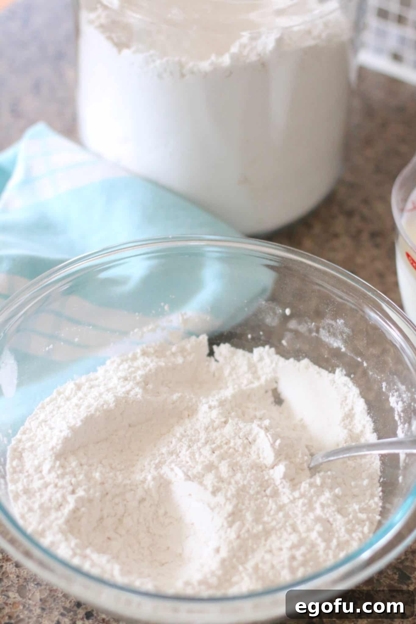 Golden Butter Biscuits 7 All-purpose flour, baking powder, and salt are stirred together in a glass Pyrex bowl with a fork.