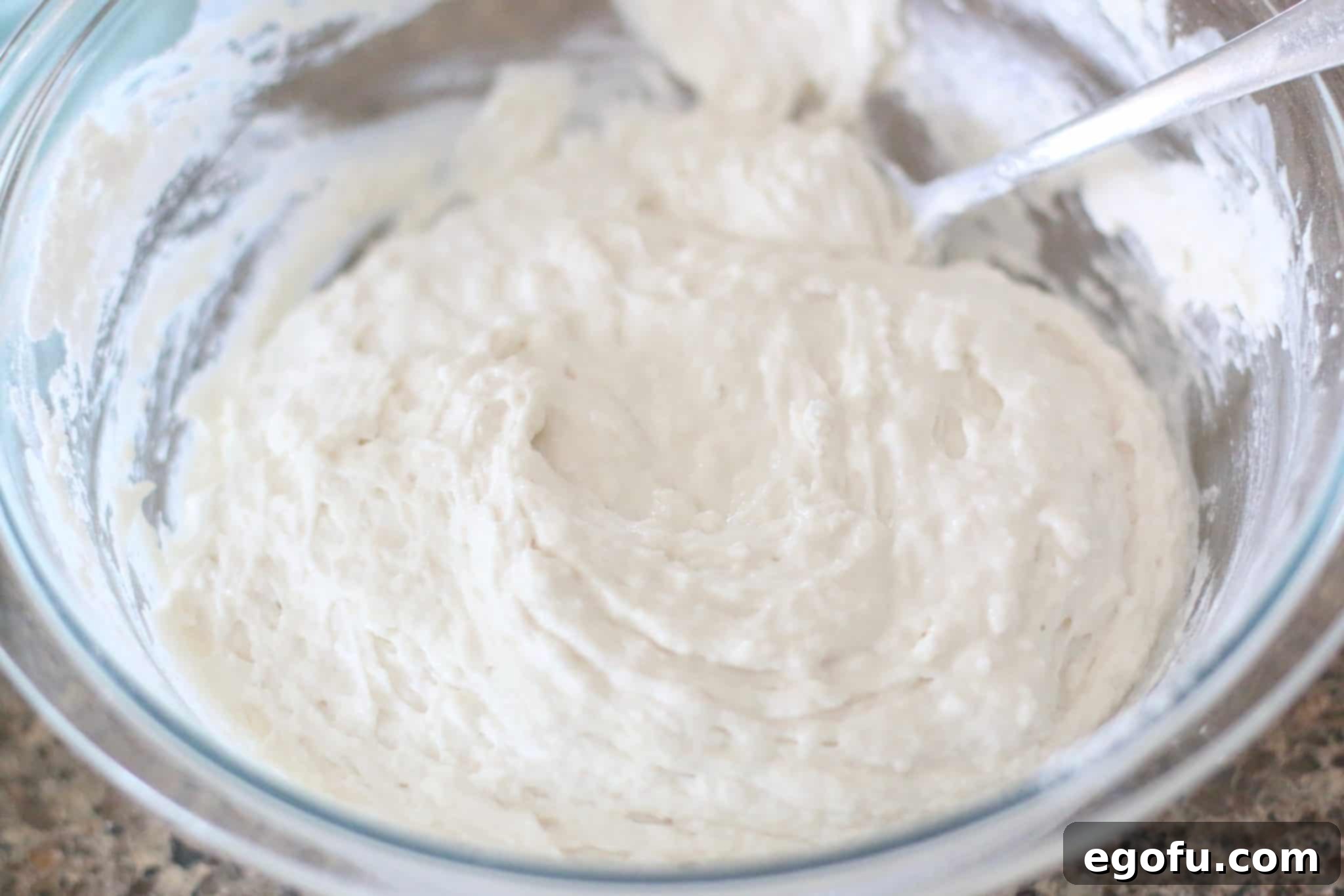 Golden Butter Biscuits 9 The buttermilk biscuit batter is stirred until it forms a loose, sticky consistency in a glass Pyrex bowl.