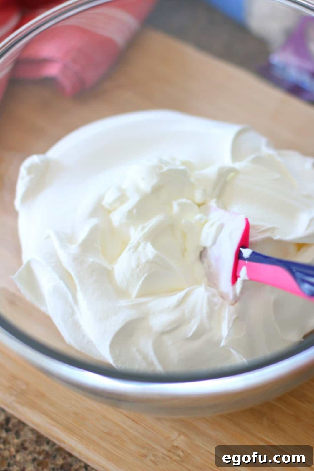 Southern Ambrosia Delight 5 Sour cream and whipped cream in a large glass bowl.