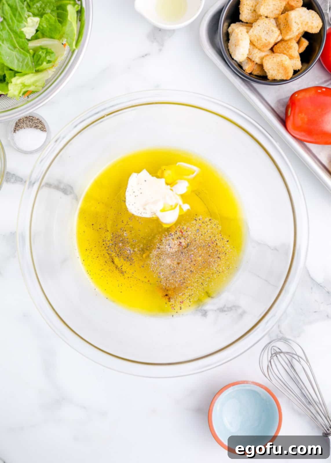 All additional ingredients being added to the prepared Italian dressing base in a mixing bowl.