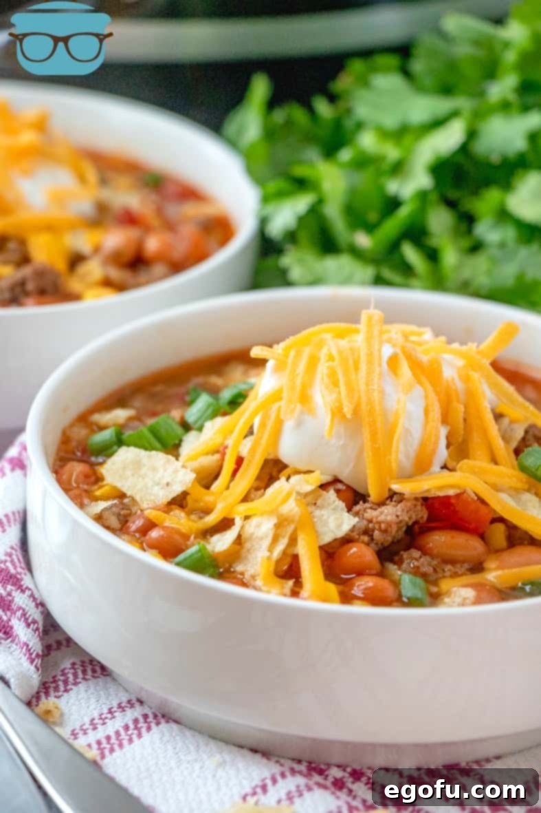 Hearty Slow Cooker Taco Soup 2 Crock Pot Taco Soup in a bowl served with tortilla chips, sour cream and shredded cheese.