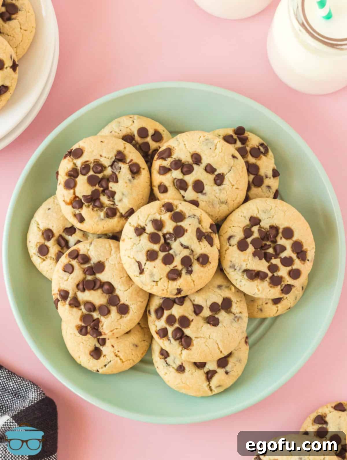 Stacked Chocolate Chip Cream Cheese Cookies on a vibrant green plate, showcasing their thick, soft texture and abundant chocolate chips.