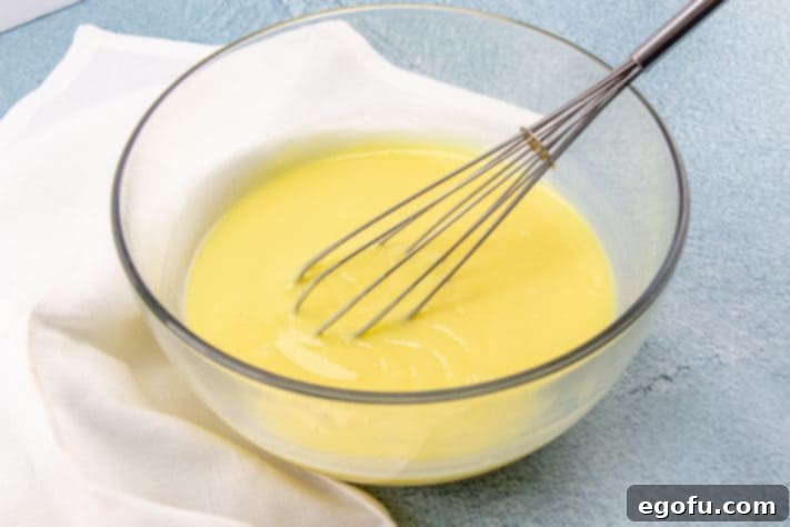 Instant pudding and milk being whisked together in a bowl until slightly thickened.
