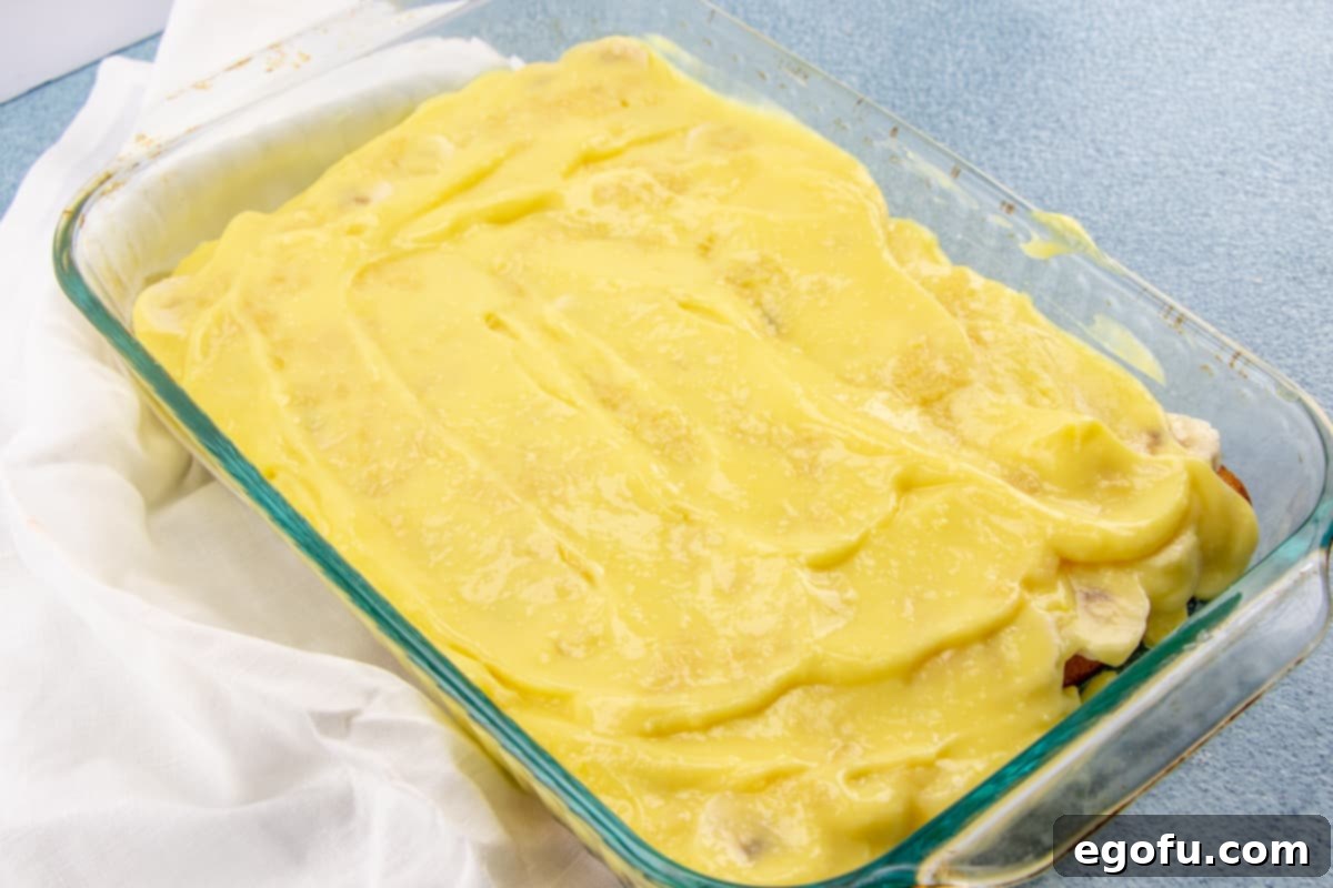Smooth instant pudding spread over the pineapple and banana layers in the baking pan.
