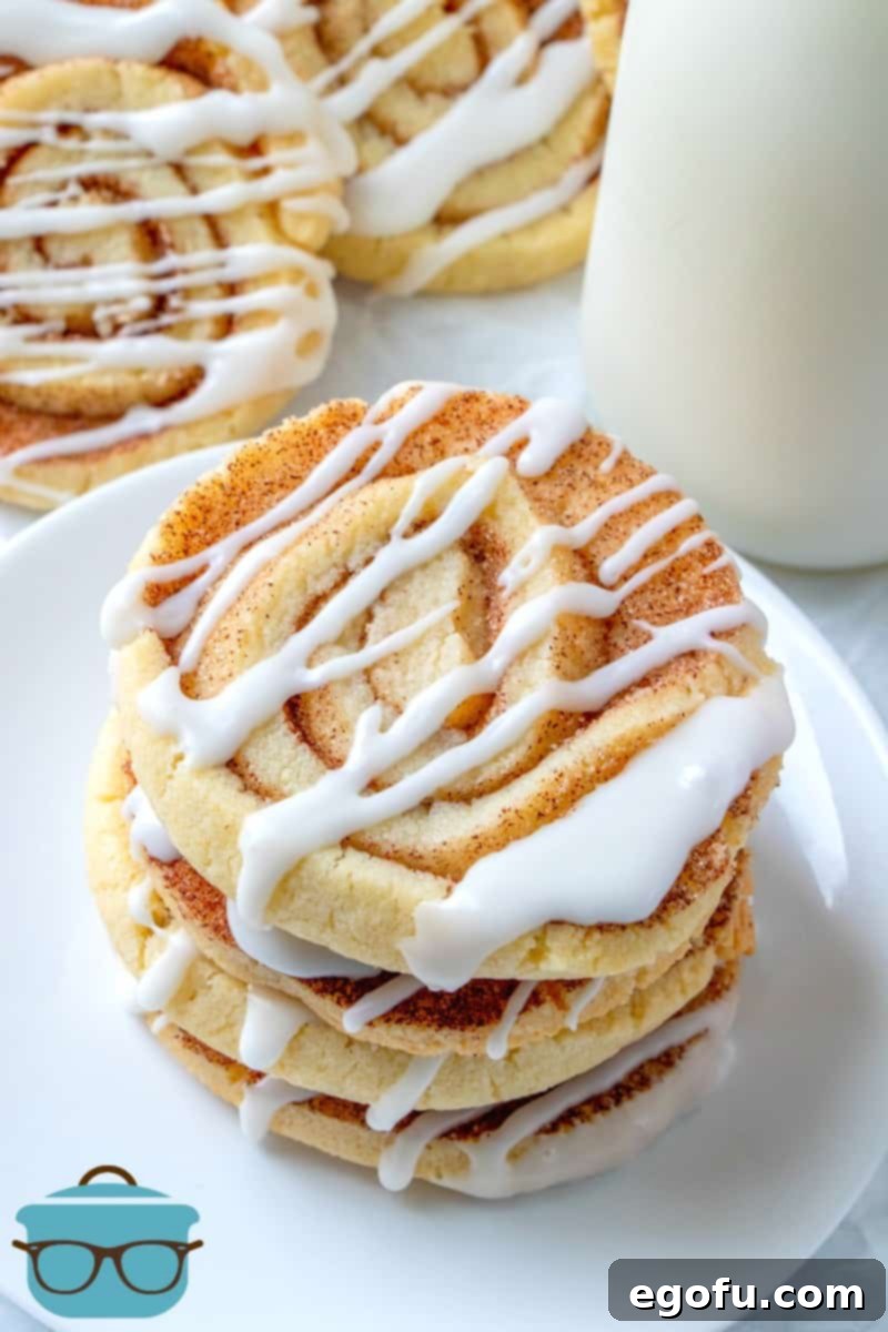 Cinnamon Roll Cookies stacked on a white plate served with a bottle of cold milk