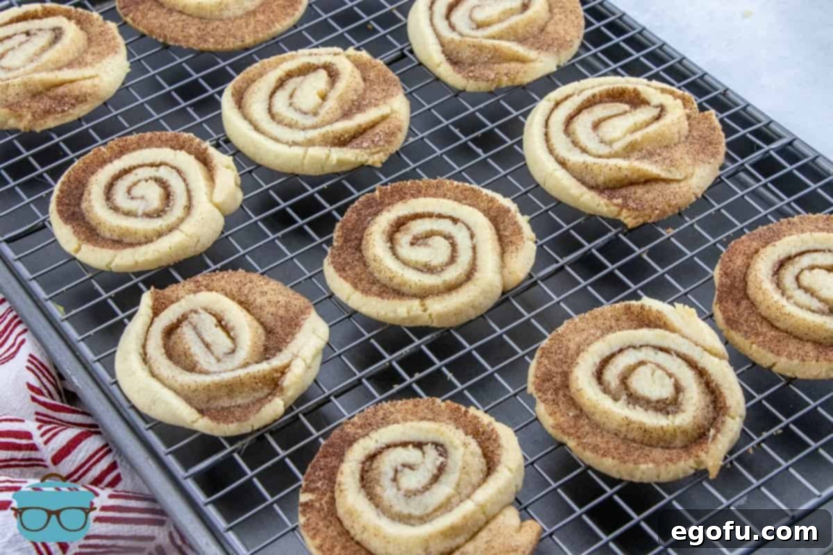 Fully baked Cinnamon Roll-style cookies cooling on a baking rack, golden and delicious.