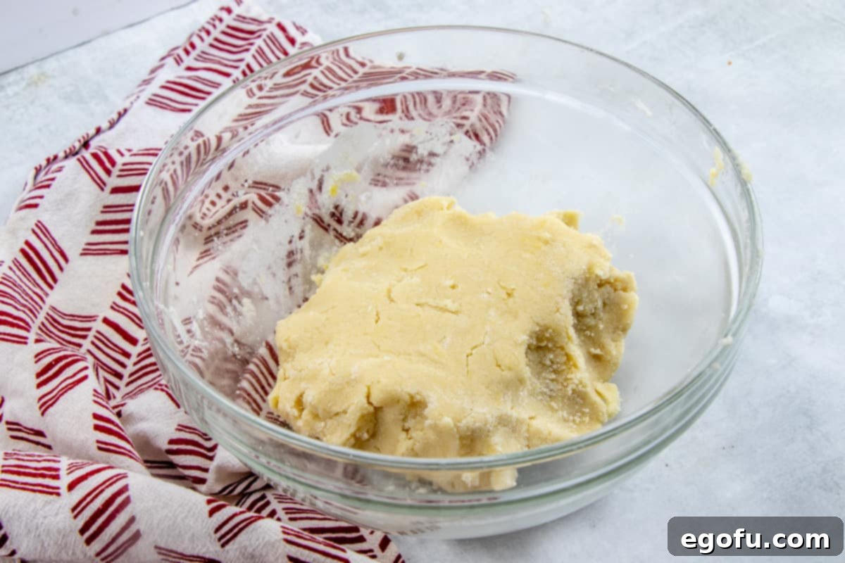 Sugar cookie dough shown in a clear bowl, ready for rolling.