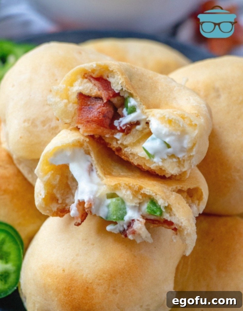 Zesty Jalapeño Delights 2 Golden-baked Jalapeño Popper Bites, showcasing their flaky crescent roll exterior and a peek at the creamy, spicy filling.
