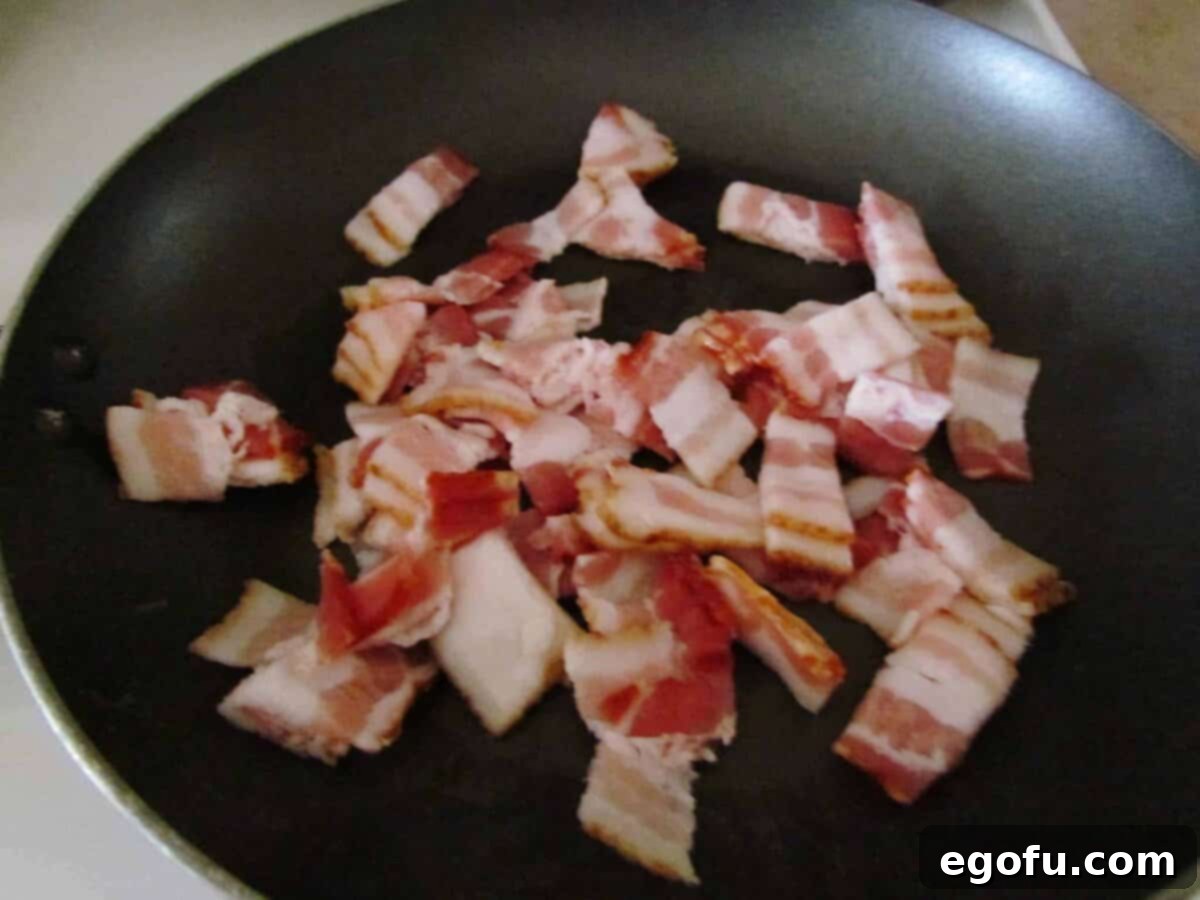 Zesty Jalapeño Delights 5 Chopped bacon sizzling in a pan, cooking to a perfect crispness before being added to the popper bites.