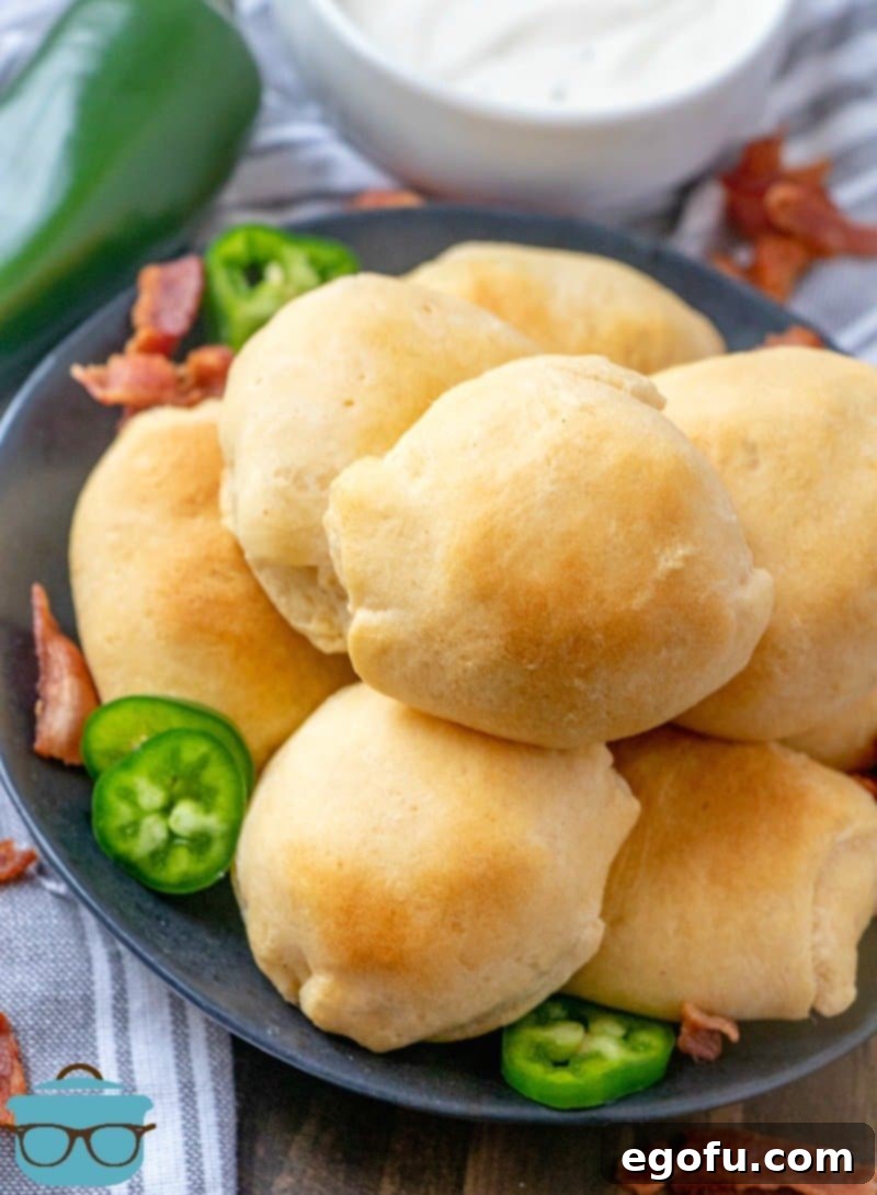 Zesty Jalapeño Delights 10 Freshly baked Jalapeño Popper Bites on a plate, garnished with extra sliced jalapeños and crispy bacon for an appealing presentation.