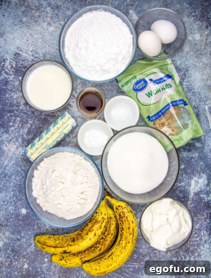 A rustic display of fresh, ripe bananas, alongside butter, all-purpose flour, vanilla extract, baking soda, eggs, powdered sugar, and chopped walnuts—all the ingredients for a delicious banana cake.