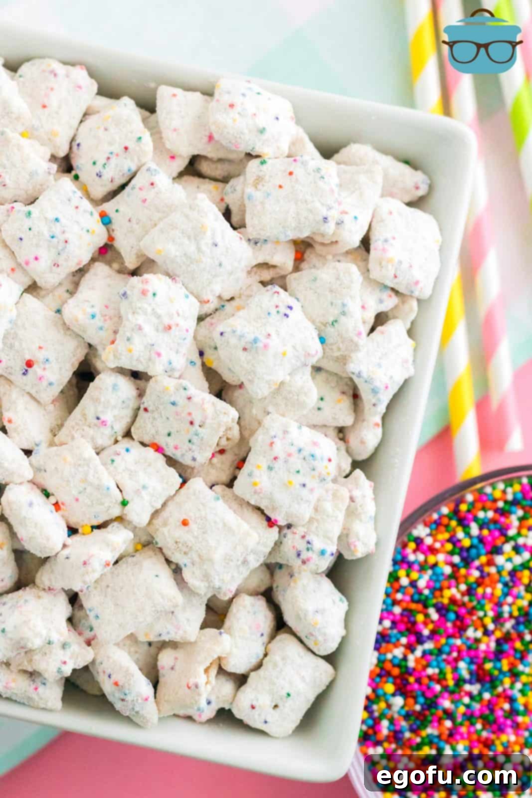 Celebration Confetti Crunch 2 Overhead shot of a vibrant bowl of Funfetti Puppy Chow, generously adorned with extra colorful sprinkles, ready for serving.
