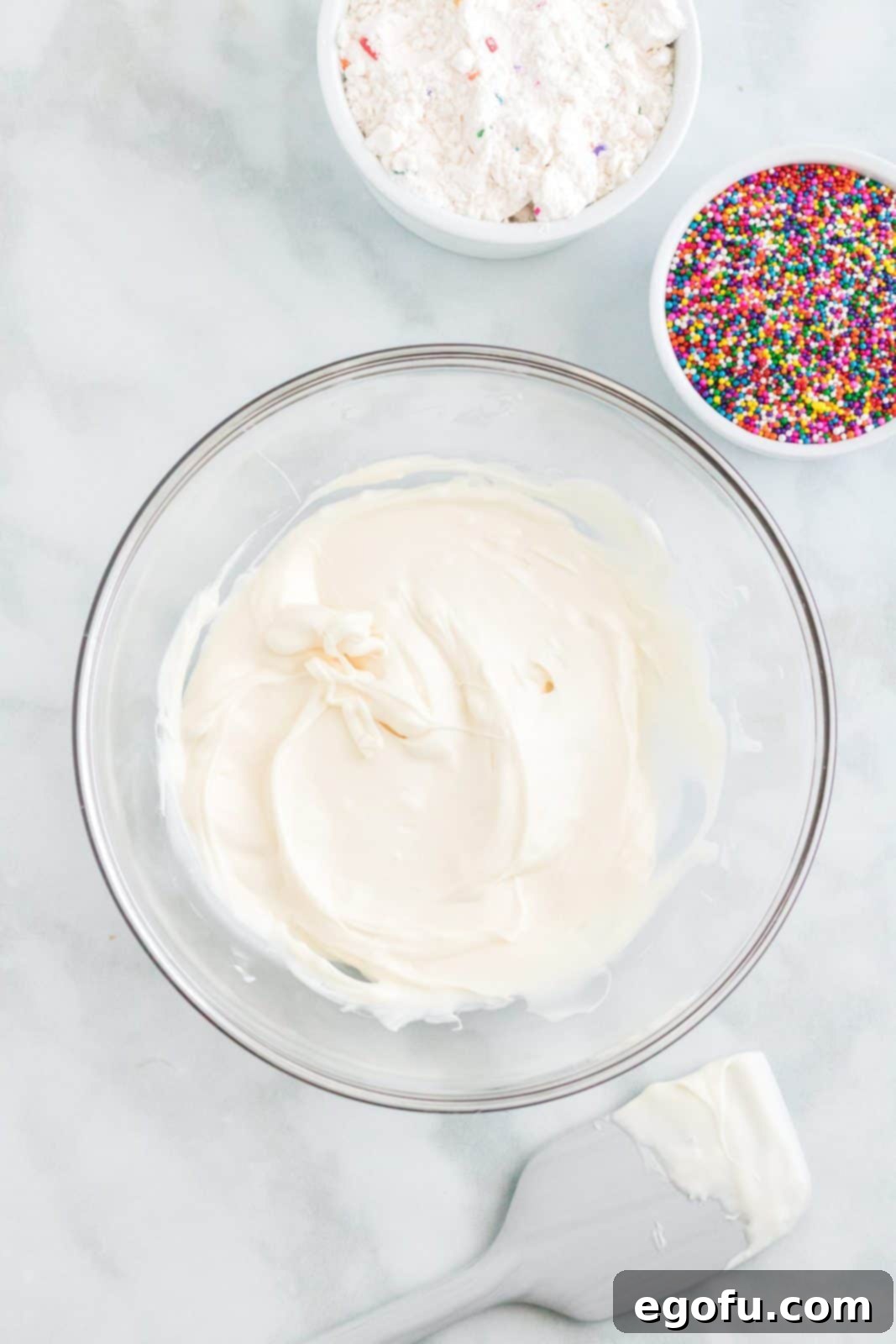 Celebration Confetti Crunch 5 Smooth, perfectly melted white candy melts in a glass bowl, showcasing their creamy texture, ready for the next step.