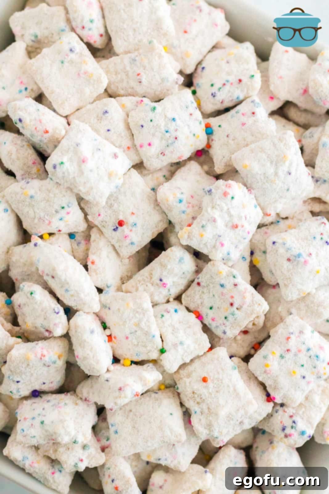 Celebration Confetti Crunch 9 A generous spread of finished Funfetti Puppy Chow, presented close-up, highlighting its vibrant colors and powdery coating.