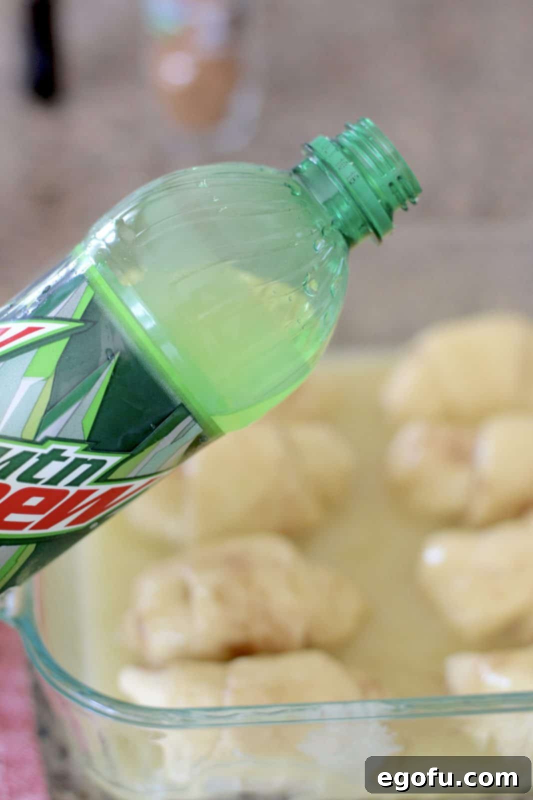 Sweet Apple Pockets 12 Lemon-lime soda being carefully poured around the edges of the crescent roll bundles in a baking dish, creating the base for the delicious sauce.