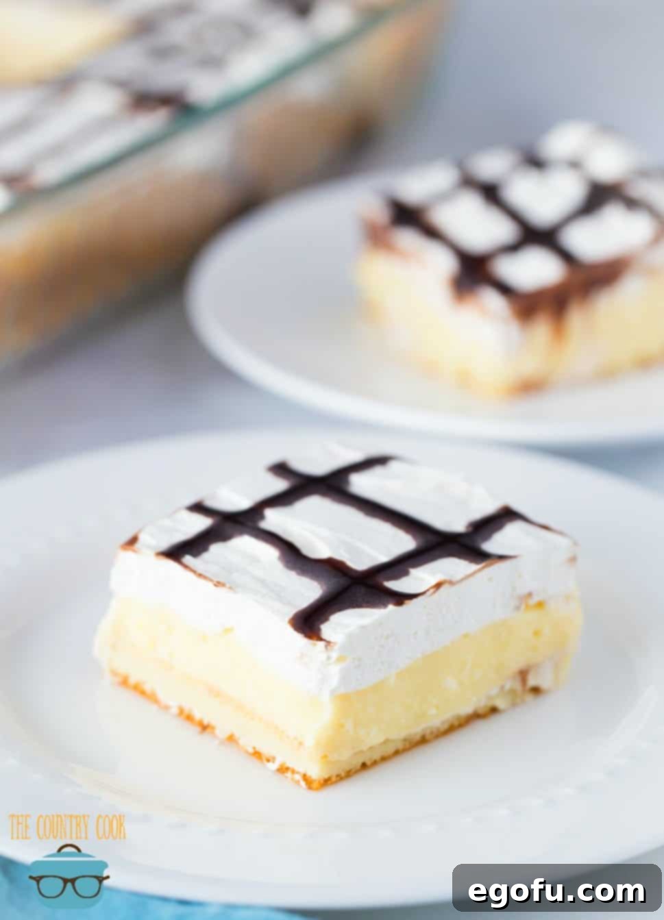 Easy Cream Puff Dessert, slices on round white plates, ready to be served.