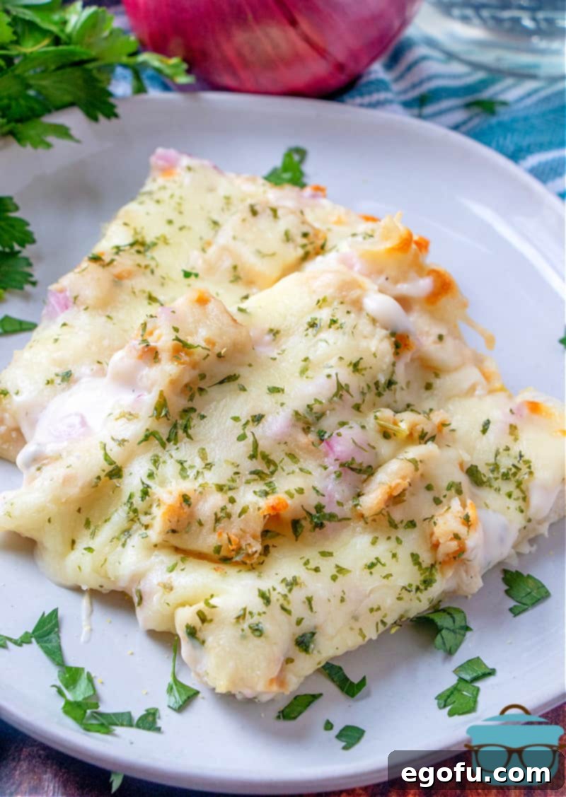 Two slices of grilled chicken Alfredo pizza on a white plate and sprinkled parsley on top.