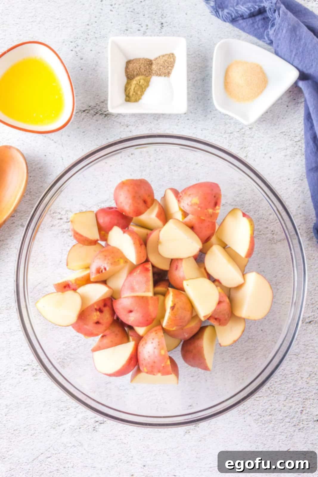Diced red baby potatoes neatly arranged in a mixing bowl, ready for seasoning.
