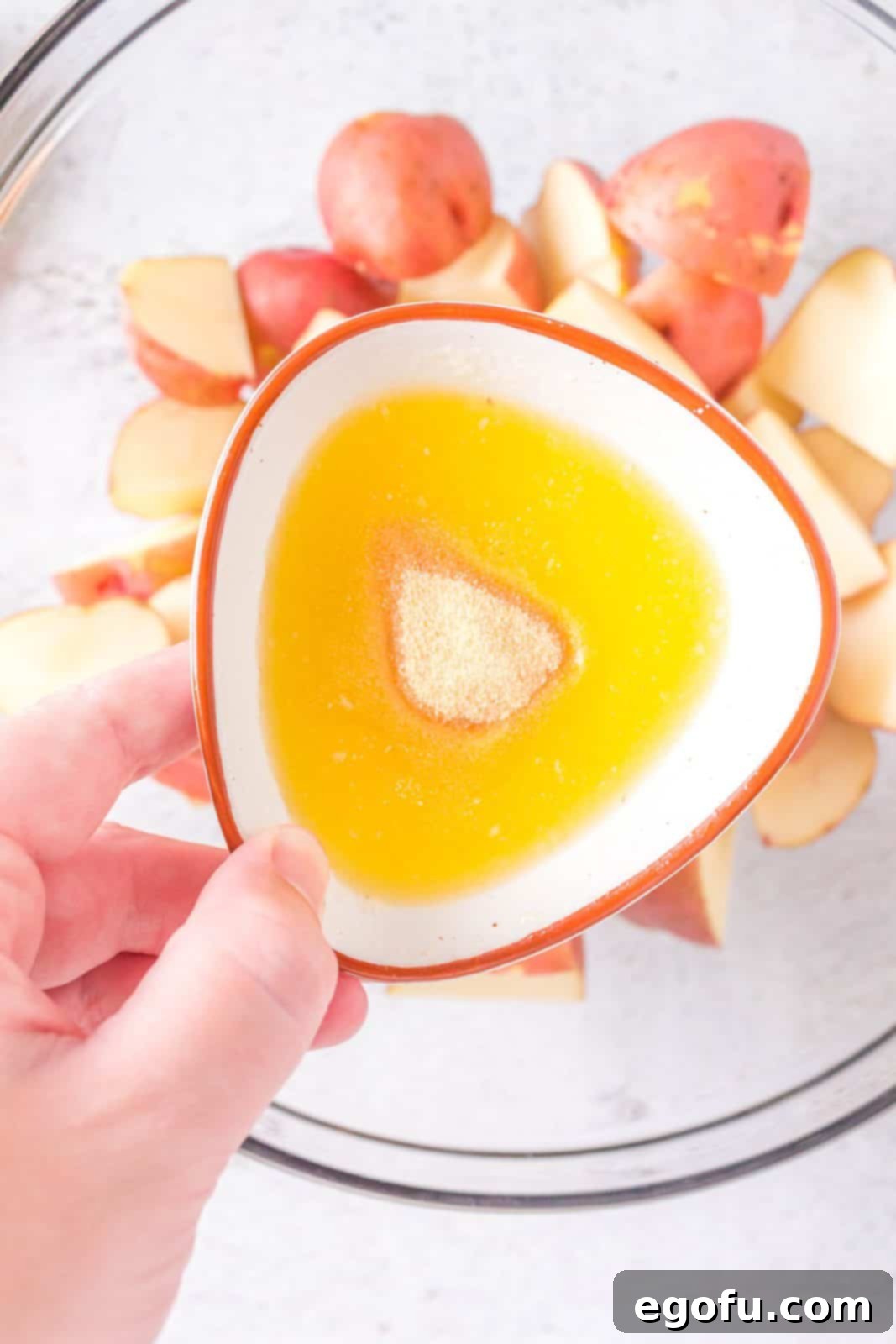 Melted butter and garlic powder perfectly mixed in a small bowl, creating an aromatic coating.